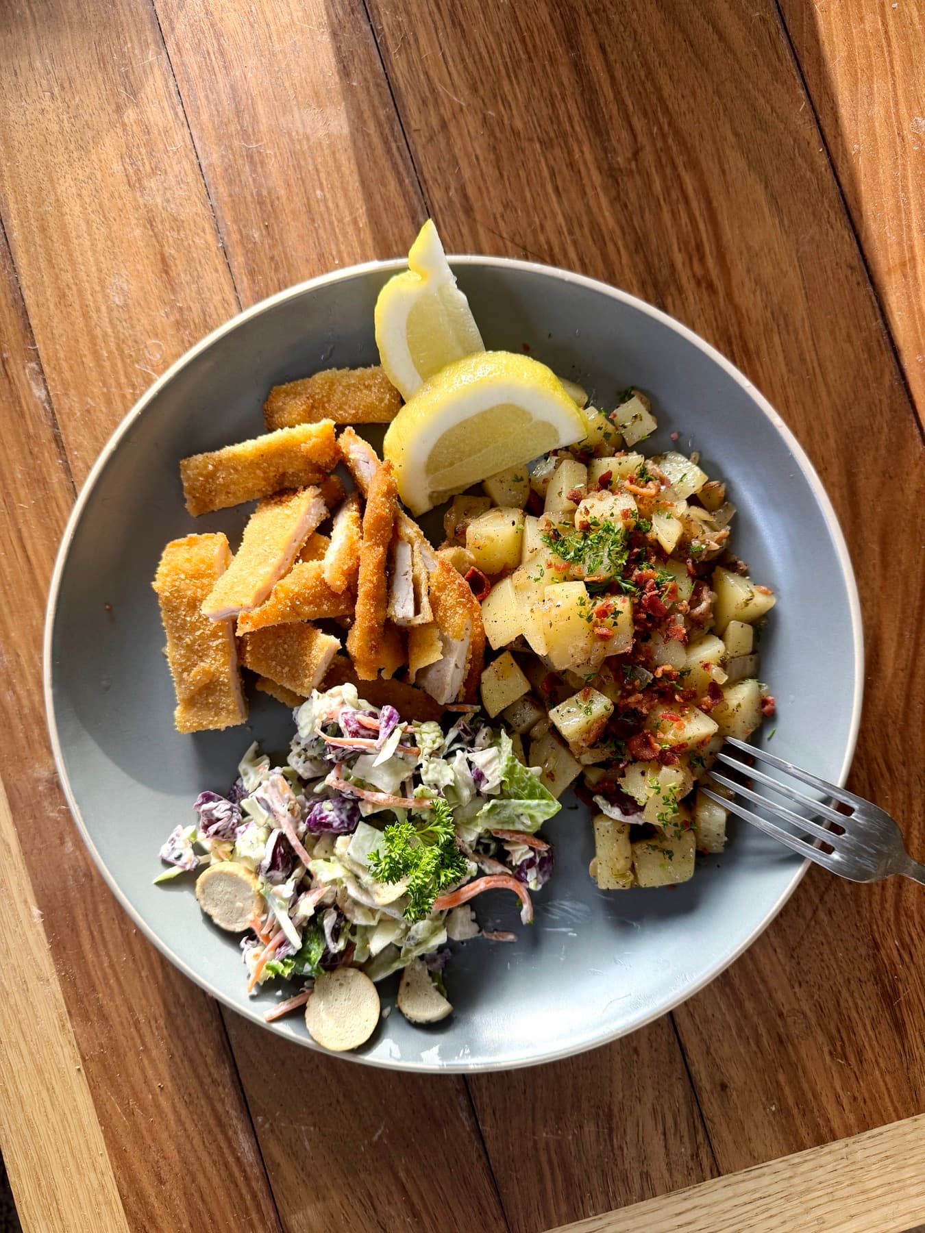 Alpine plate with schnitzel bites, roasted potatoes and slaw